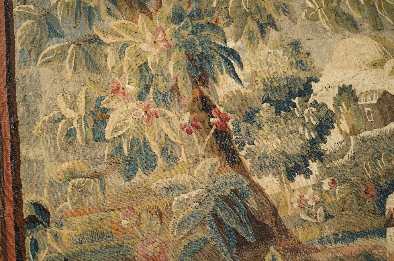 A mid to late 18th century French Aubusson tapestry of a bird, possibly a heron, within a tree lined verdure garden scene to a chateaux, with an ornate rust coloured contrasting tapestry border.201cm x 170 cm. Condition